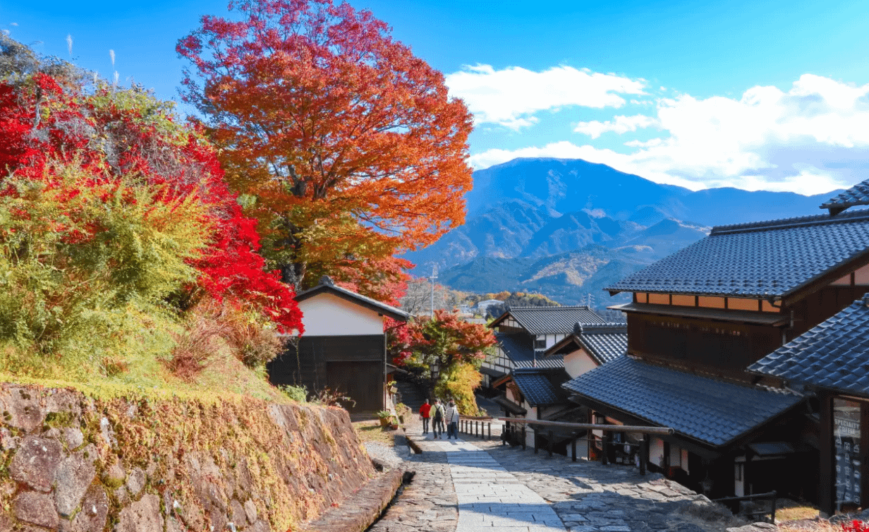 Nakasendo amb colors de tardor i vistes de muntanyes al fons.