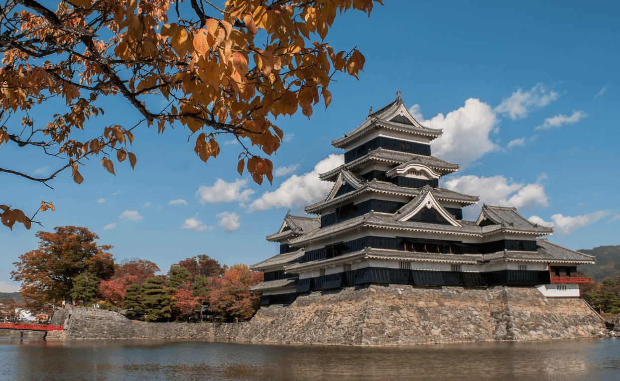 Castell de Matsumoto vist des del fossat, amb la seva silueta negra reflectida perfectament a l’aigua.