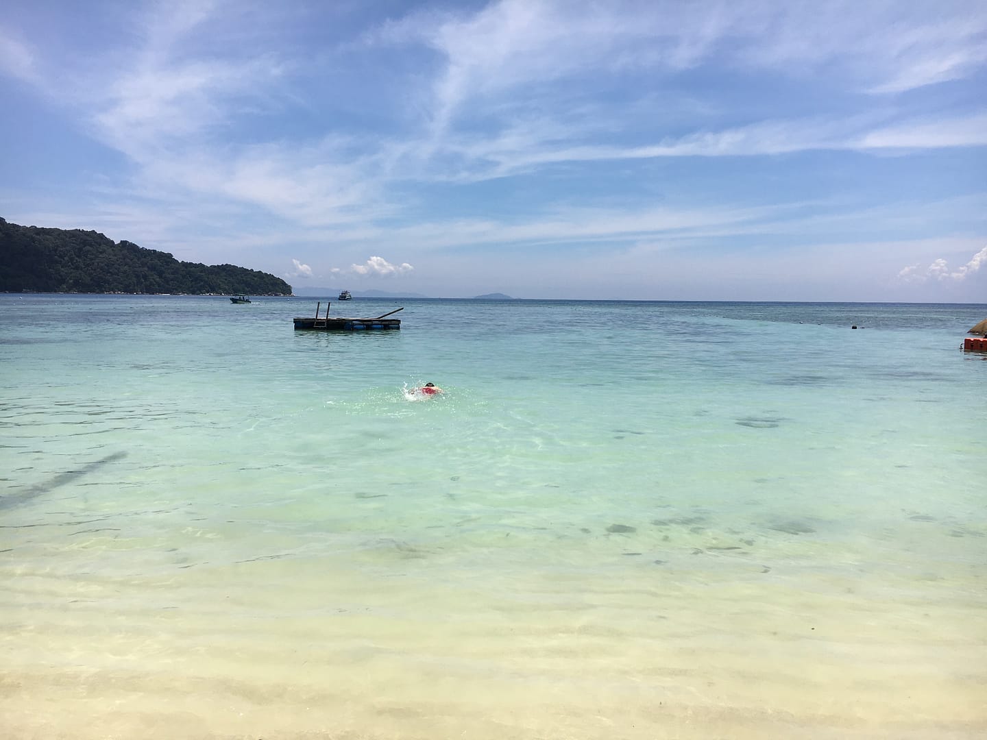 Vista d’una platja tropical a Perhentian Besar amb palmeres, sorra blanca i mar cristal·lí
