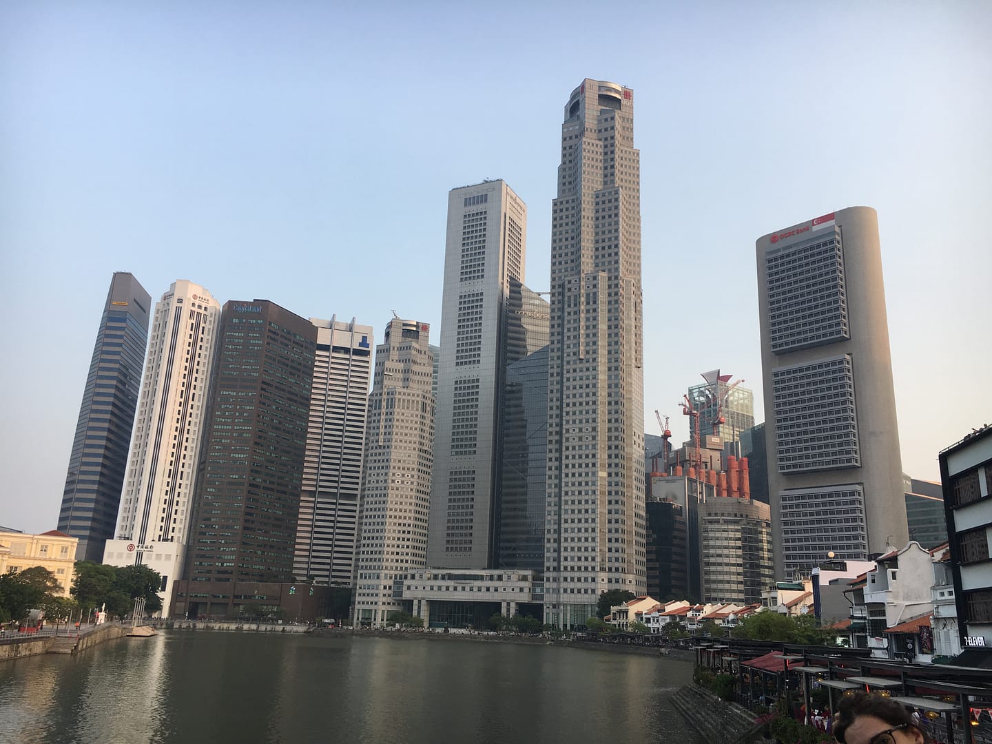 Vista panoràmica dels gratacels de Marina Bay al costat del riu Singapur, amb reflexos urbans i arquitectura moderna