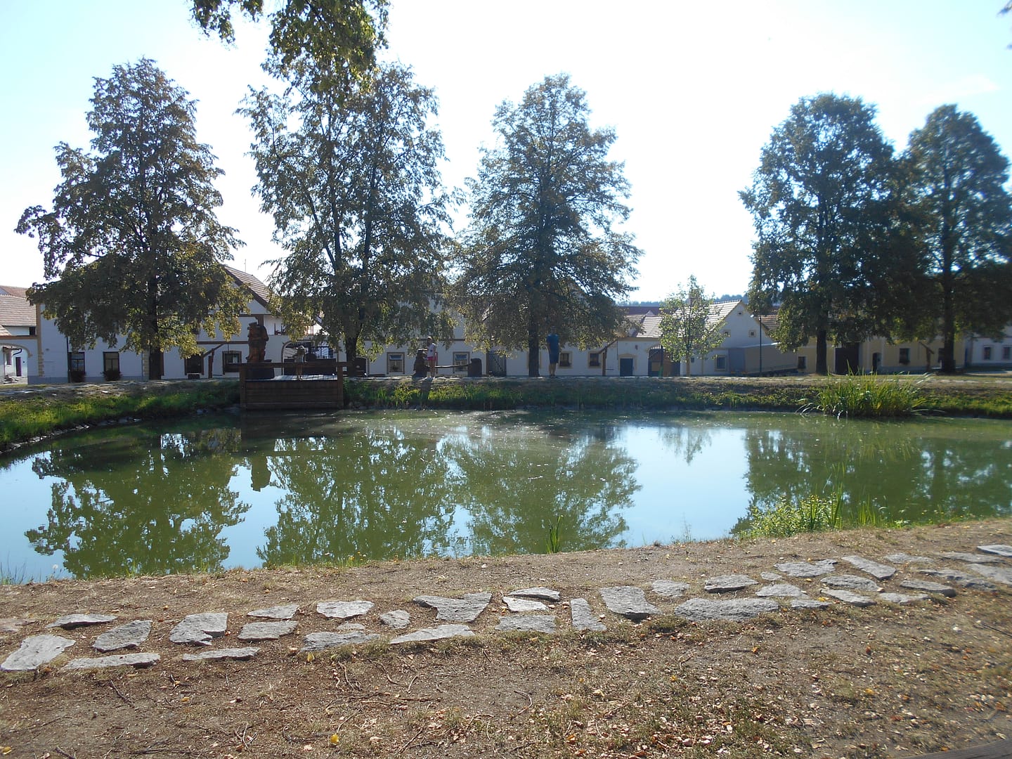 Vista d’Holašovice amb el llac i les façanes tradicionals del poble