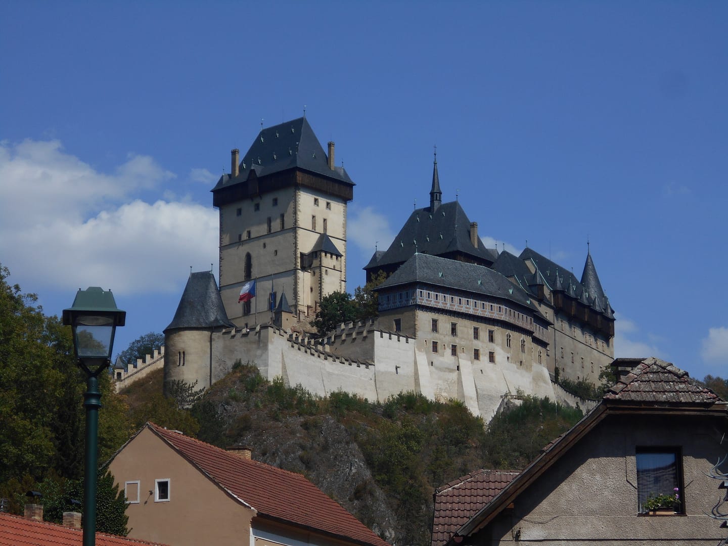 Castell de Karlštejn vist des del poble, amb les torres medievals sobre la muntanya