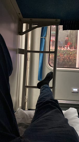 Literes metàl·liques dins d’un tren nocturn entre Beijing i Pingyao, amb llum tènue i atmosfera tranquil·la.