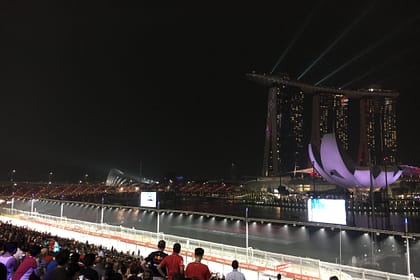 Vista lateral nocturna del Marina Bay Sands i l’ArtScience Museum amb reflexos a la badia de Singapur