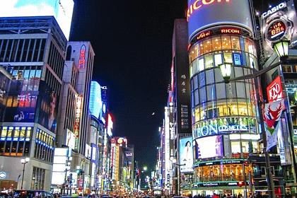 Carrers il·luminats de Ginza amb botigues de luxe i vianants al vespre.