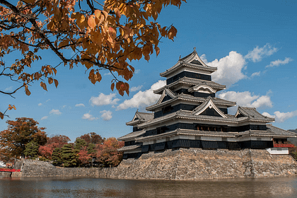 Castell de Matsumoto vist des del fossat, amb la seva silueta negra reflectida perfectament a l’aigua.