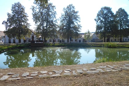 Vista d’Holašovice amb el llac i les façanes tradicionals del poble