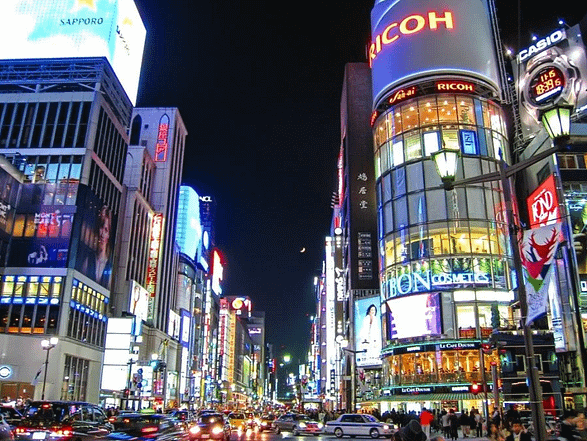 Carrers il·luminats de Ginza amb botigues de luxe i vianants al vespre.