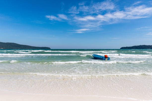 Barca tradicional atracada a Saracen Bay, Koh Rong Sanloem, envoltada d’aigües turqueses i jungla tropical