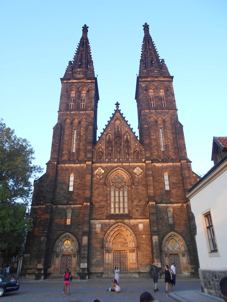 Praga al vespre amb església il·luminada — Vista nocturna de Praga amb una església destacada i llums càlides.