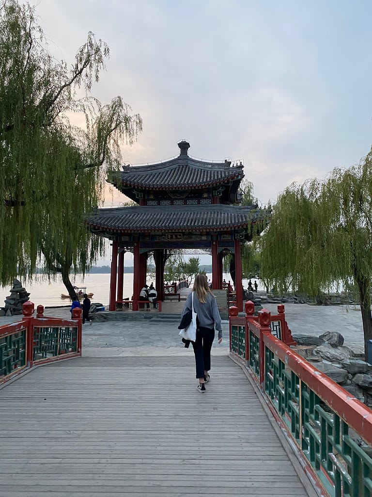 Pont de pedra sobre el llac Kunming amb torres decoratives del Palau d’Estiu al fons