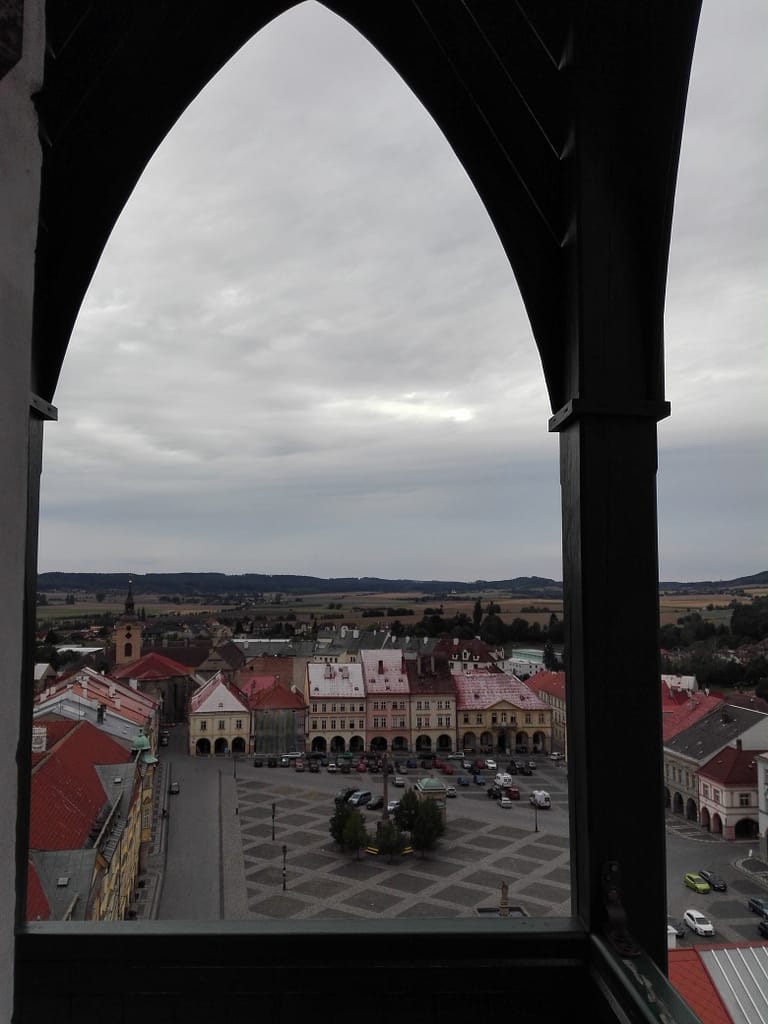 Vista de la plaça de Jičín des d’un punt elevat, emmarcada per una arcada del centre històric