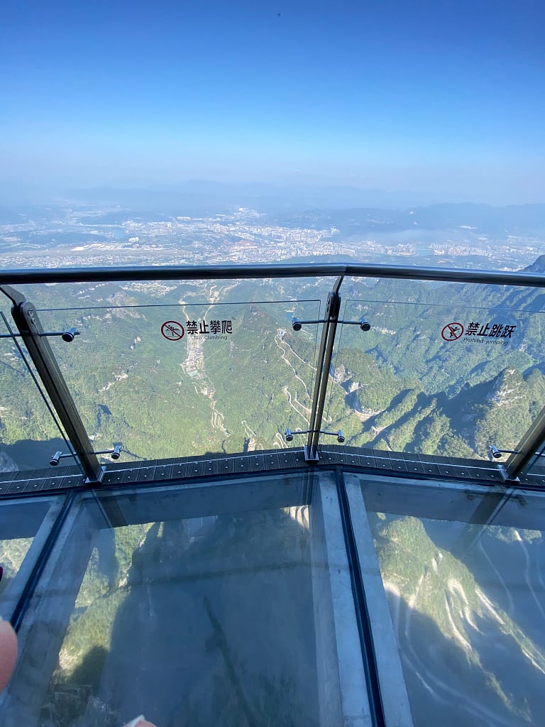 Turistes caminant per la passarel·la de cristall suspesa a la muntanya Tianmen, amb vistes panoràmiques de Zhangjiajie