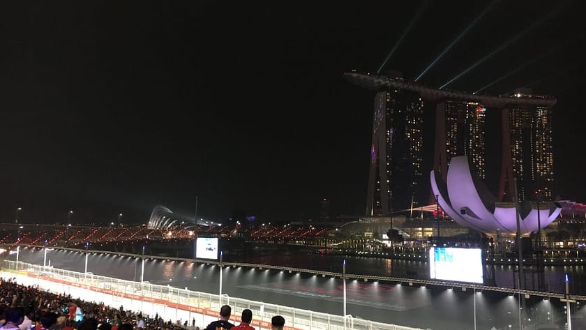 Vista lateral nocturna del Marina Bay Sands i l’ArtScience Museum amb reflexos a la badia de Singapur