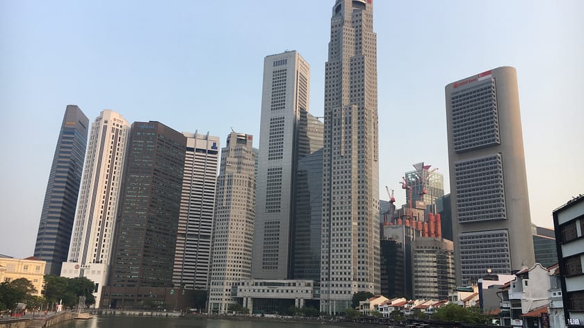 Vista panoràmica dels gratacels de Marina Bay al costat del riu Singapur, amb reflexos urbans i arquitectura moderna