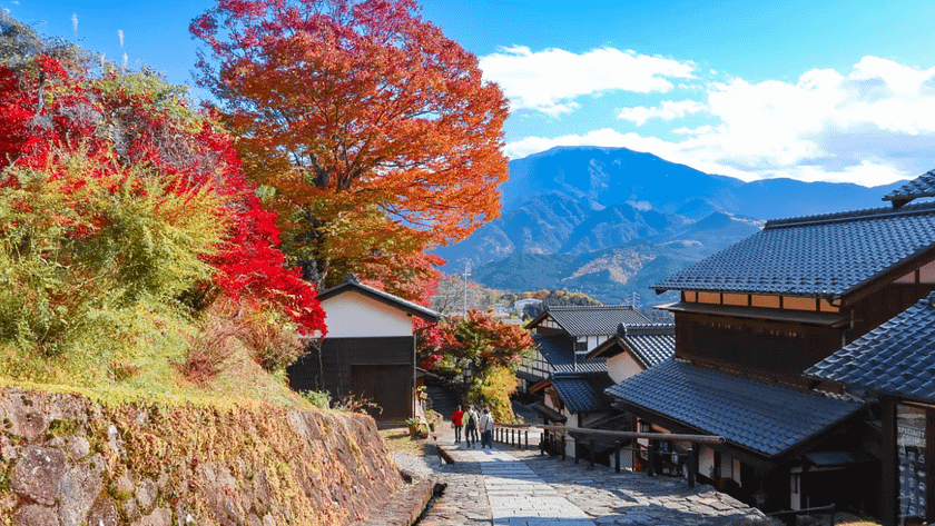 Nakasendo amb colors de tardor i vistes de muntanyes al fons.