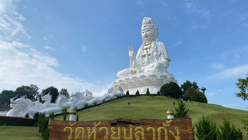 Estàtua gegant de Guan Yin al temple Wat Huay Pla Kang de Chiang Rai, envoltada de paisatge verd i cel clar