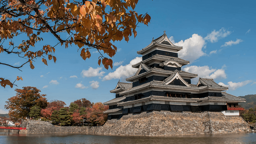 Castell de Matsumoto vist des del fossat, amb la seva silueta negra reflectida perfectament a l’aigua.