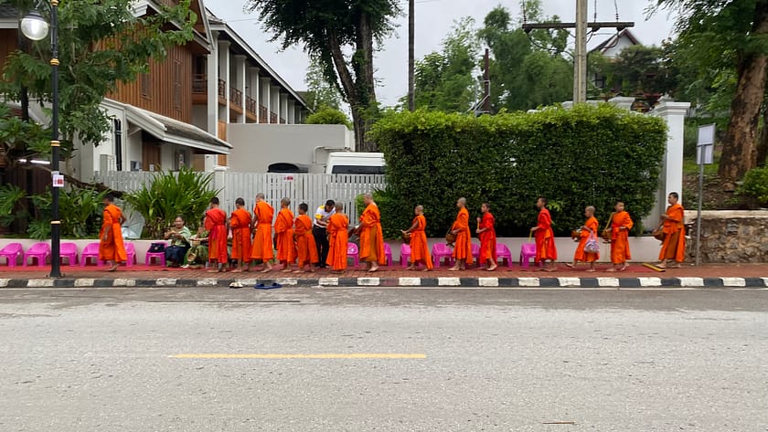 Files de monjos budistes recollint almoines a Luang Prabang, una tradició espiritual imprescindible per descobrir què fer a Luang Prabang