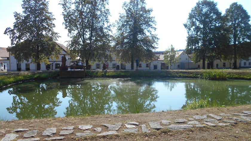 Vista d’Holašovice amb el llac i les façanes tradicionals del poble