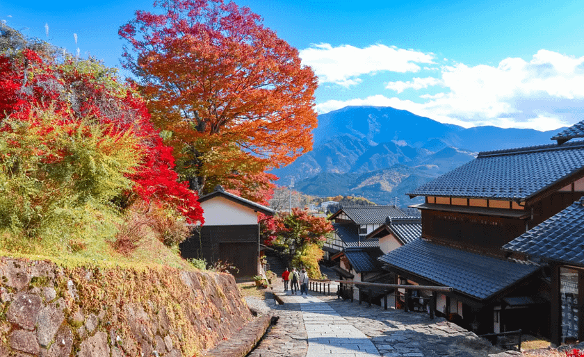 Nakasendo amb colors de tardor i vistes de muntanyes al fons.