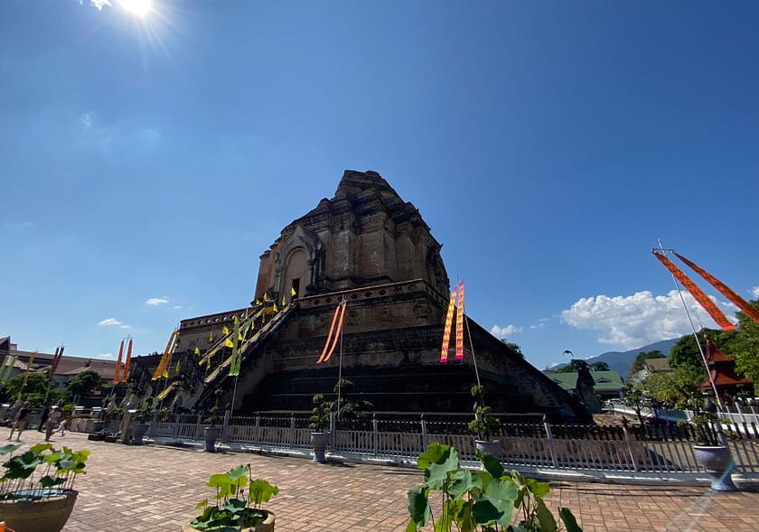 Exterior del Wat Chedi Luang amb fonaments antics i vegetació, temple històric de Chiang Mai