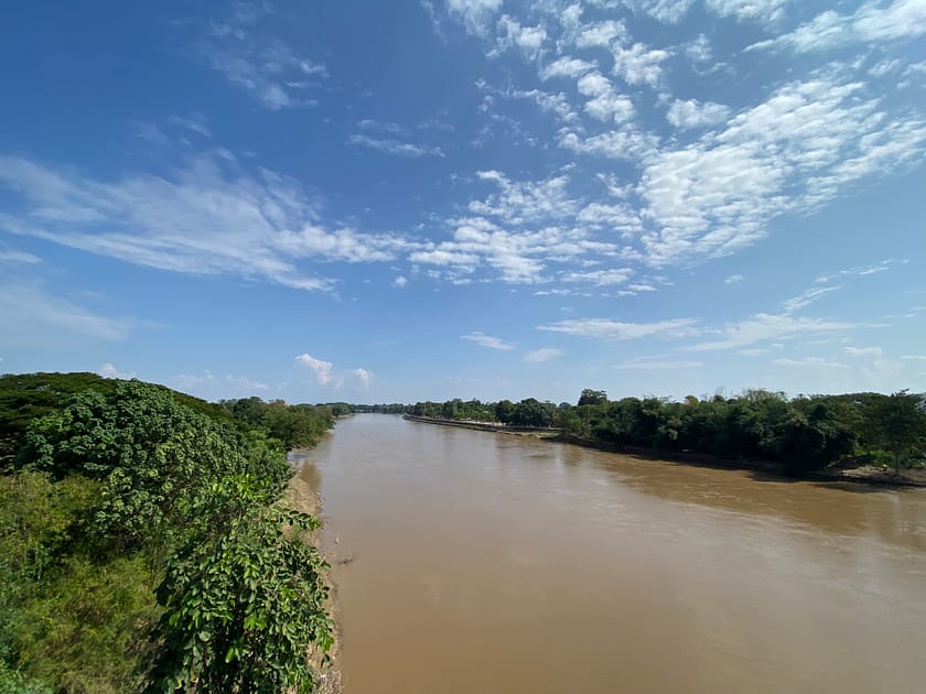 Vista del riu que travessa Chiang Rai amb vegetació tropical i cel obert