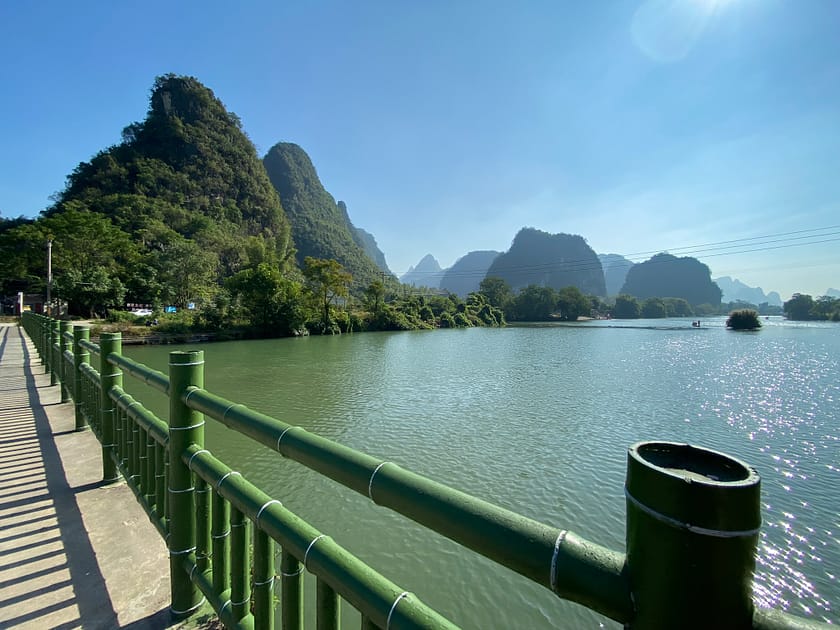 Barques de bambú navegant pel riu Yulong amb muntanyes kàrstiques al fons i gent gaudint del paisatge