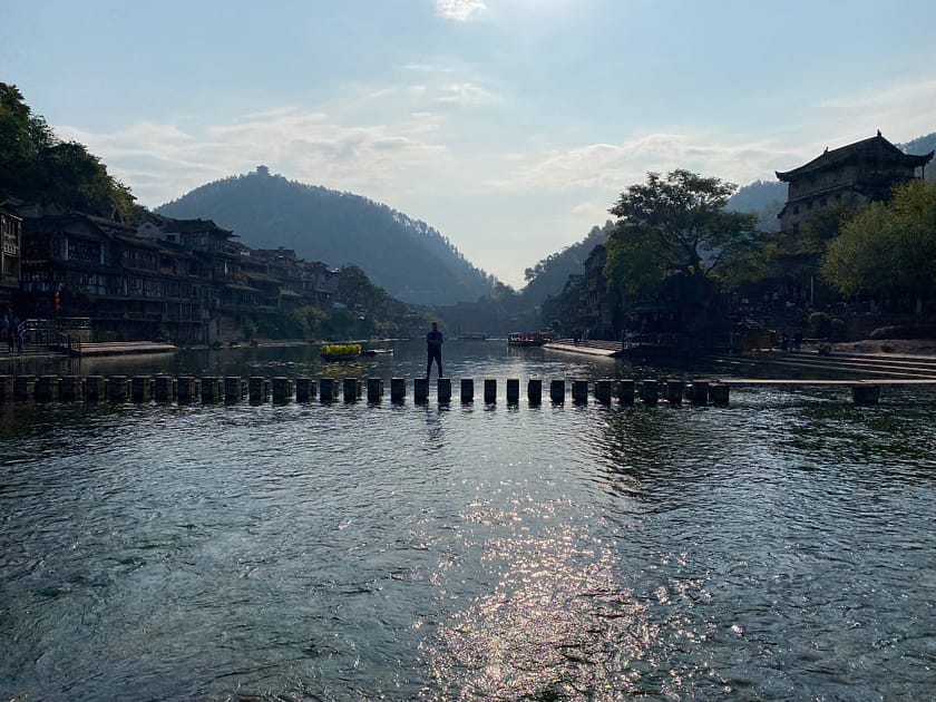 Camí de pedres que creua el riu Tuo a Fenghuang amb vistes a les cases penjants tradicionals