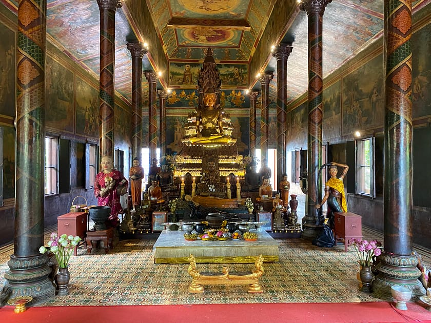 Interior del Wat Phnom amb murals budistes i estàtua de Buda – Un dia a Phnom Penh