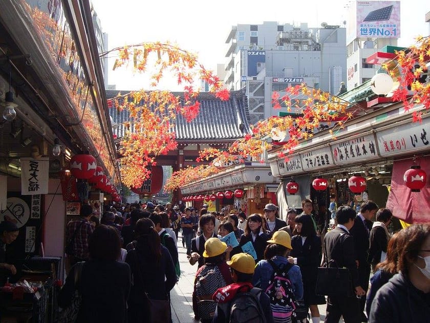 Carrer comercial d’Asakusa ple de gent, parades tradicionals i decoració de tardor.