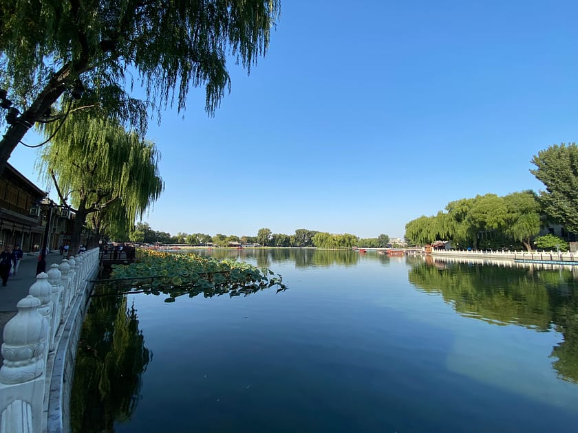 Vista serena del llac Qinhan amb muntanyes al fons i reflexos a l’aigua