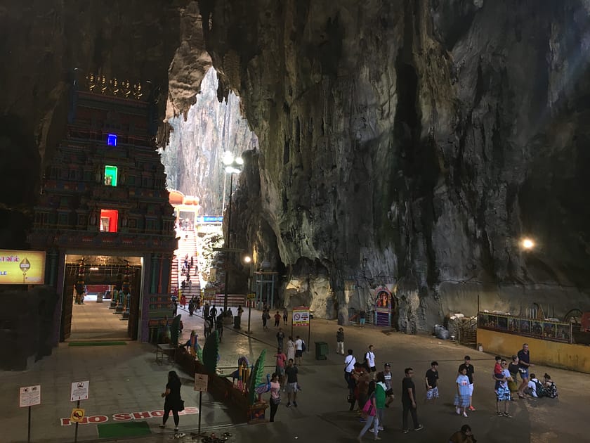 Interior de les Batu Caves amb temple hindú i parets de roca calcària.