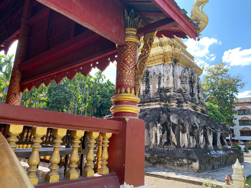 Exterior del Wat Chiang Man amb vegetació i fonaments visibles, temple històric de Chiang Mai