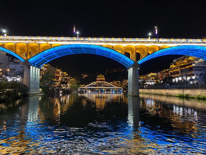 Vista nocturna del riu Tuojiang a Fenghuang amb llums reflectides i cases tradicionals