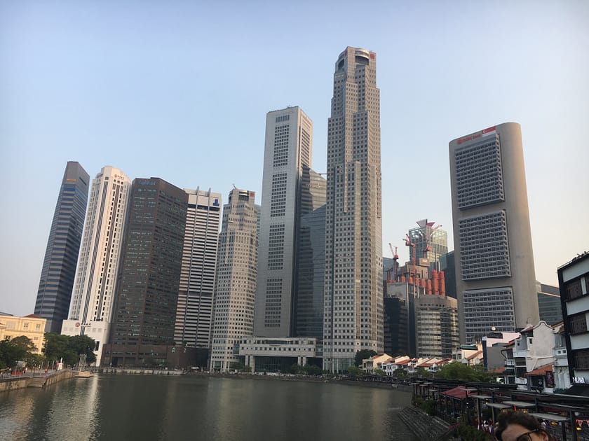 Vista panoràmica dels gratacels de Marina Bay al costat del riu Singapur, amb reflexos urbans i arquitectura moderna