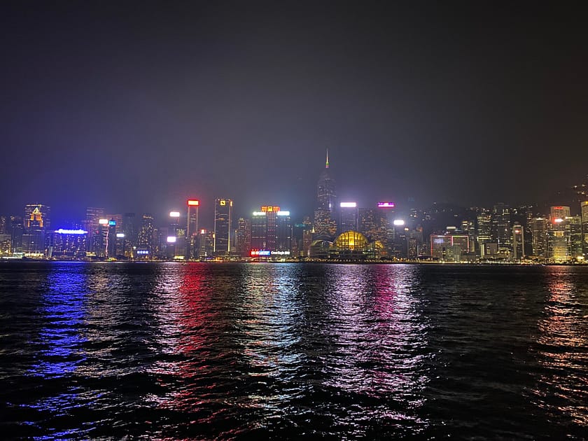 Vista nocturna de la riba de Hong Kong amb els gratacels il·luminats del districte financer reflectits sobre l'aigua