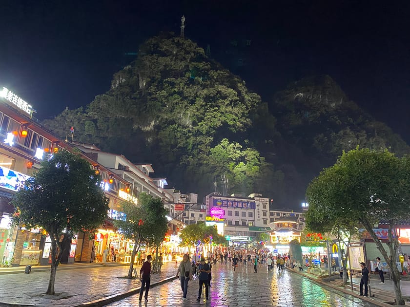 Vista nocturna de Yangshuo amb les muntanyes kàrstiques al fons i llums de la ciutat