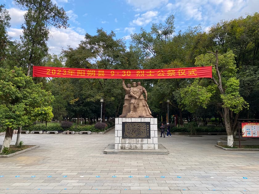 Estàtua de soldats en actitud solemne al parc de Yangshuo, envoltada de vegetació i muntanyes