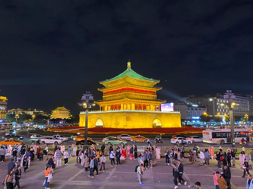 Vista nocturna de la Torre de la Campana de Xi’an il·luminada amb tons daurats i vermells