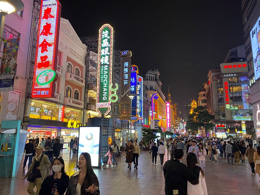 Carrer Nanjing Road de Shanghai il·luminat de nit amb vianants, llums de neó i ambient urbà