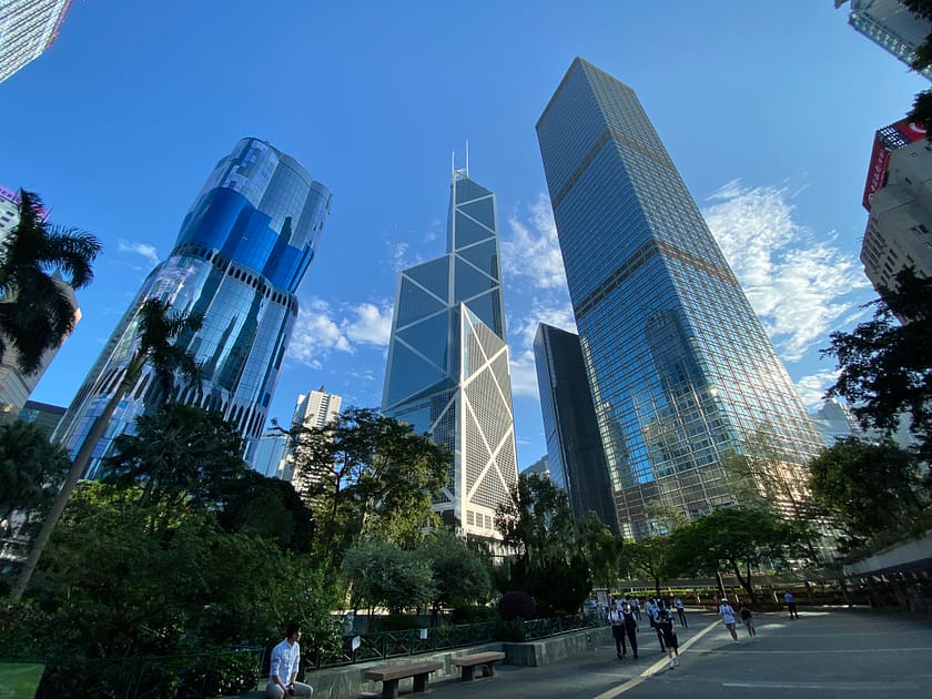 Fotografia des de la base dels gratacels del Districte Financer de Hong Kong, mostrant edificis alts i estructures de vidre