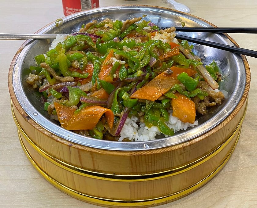 Plat d’arròs amb porc estil Shanghai servit en bol tradicional