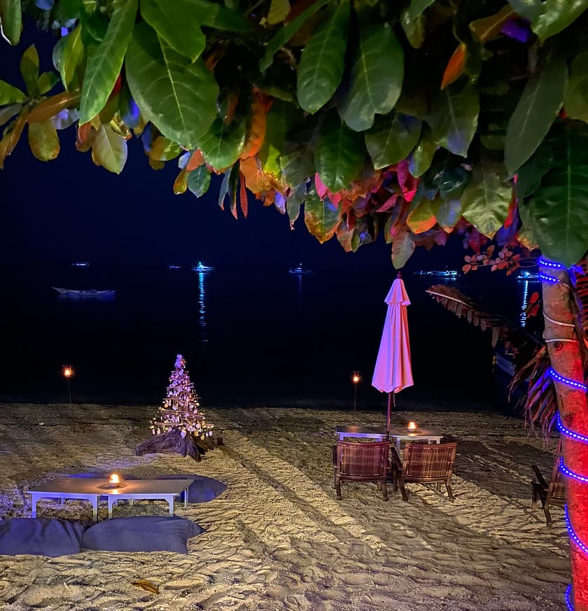 Platja de Malapascua de nit amb decoració de Nadal i llums, ambient festiu per qui descobreix com anar de Bantayan a Malapascua