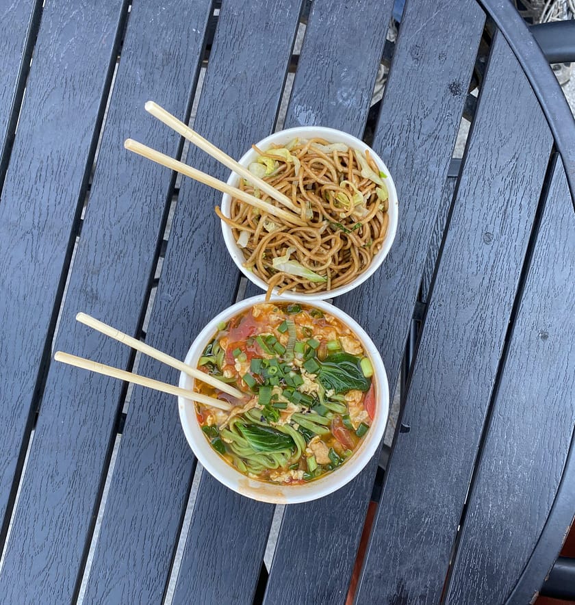 Dinar xinès amb noodles, verdures i carn en caixes per emportar, servit durant un viatge