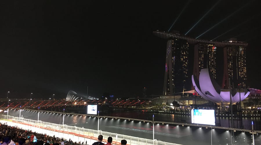 Vista lateral nocturna del Marina Bay Sands i l’ArtScience Museum amb reflexos a la badia de Singapur