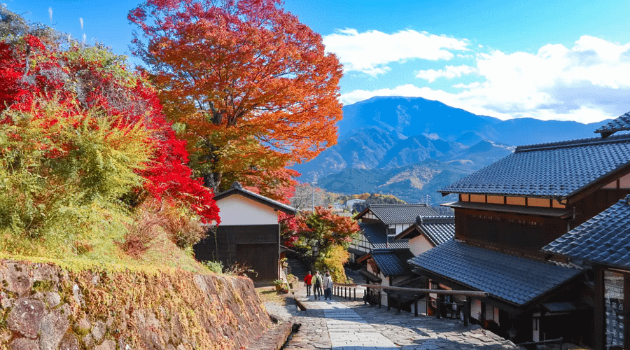 Nakasendo amb colors de tardor i vistes de muntanyes al fons.