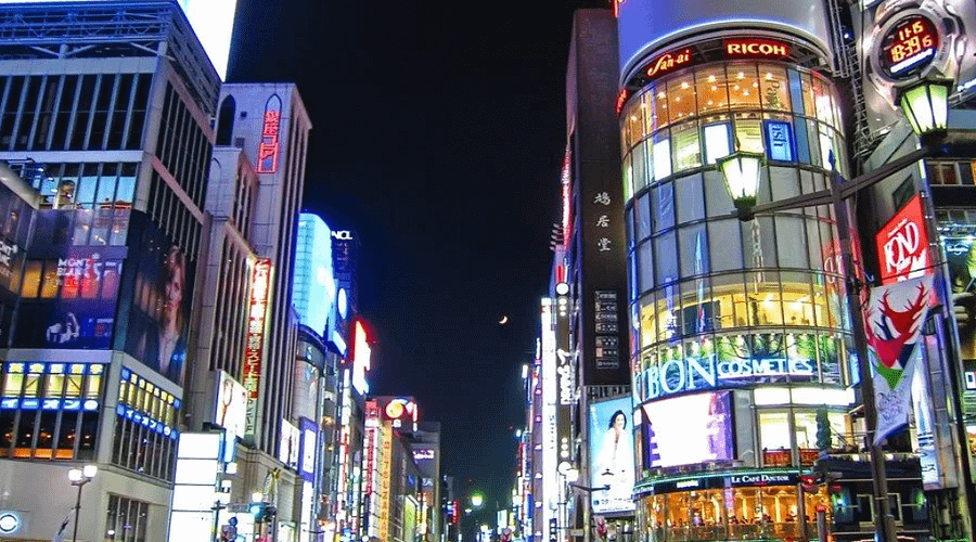 Carrers il·luminats de Ginza amb botigues de luxe i vianants al vespre.
