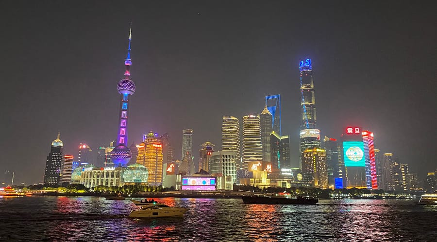 Panoràmica nocturna del Bund de Shanghai amb edificis il·luminats i reflexos sobre el riu Huangpu