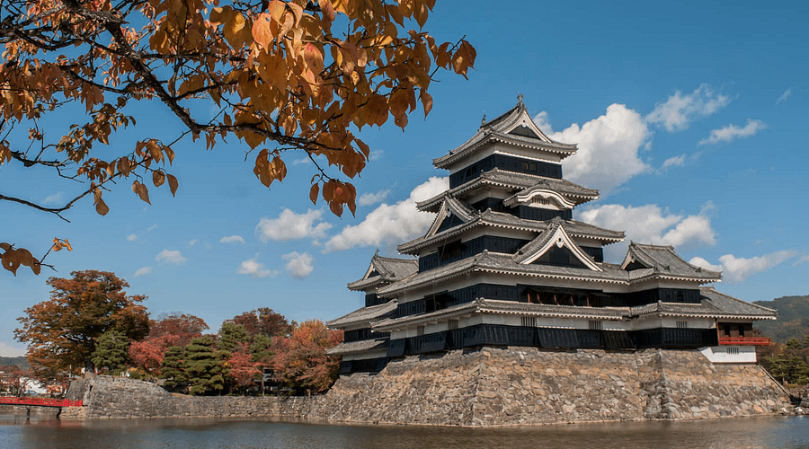 Castell de Matsumoto vist des del fossat, amb la seva silueta negra reflectida perfectament a l’aigua.